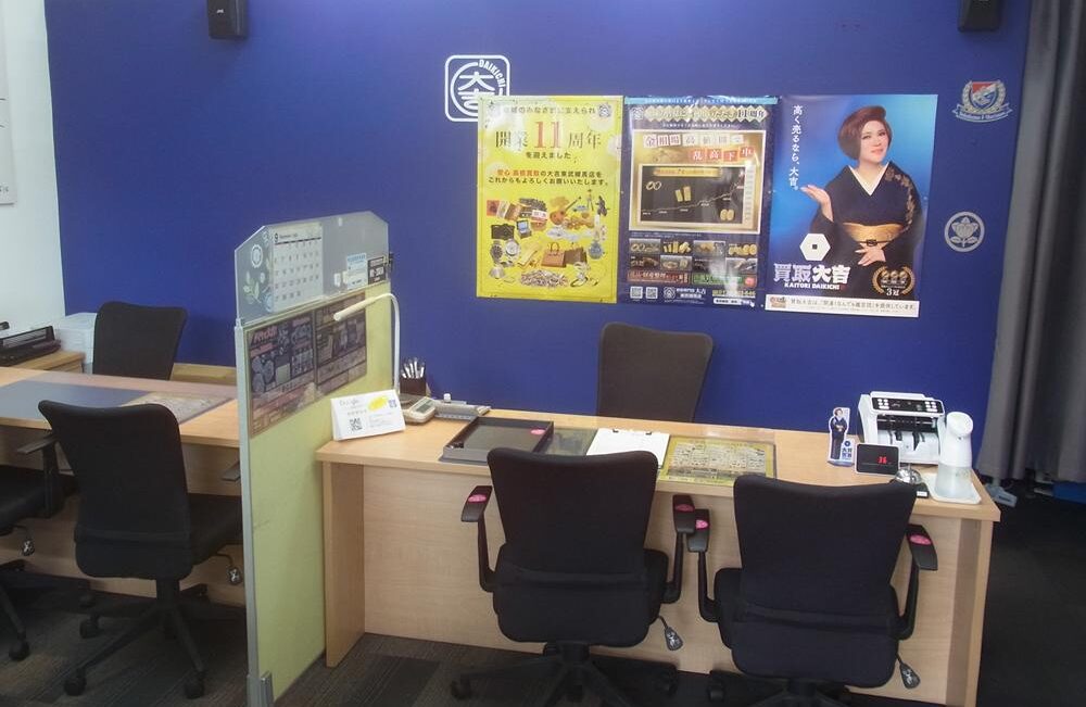 shop02 Office reception/desk area with three black swivel chairs in front of a blue wall with posters and a divider panel on the left.